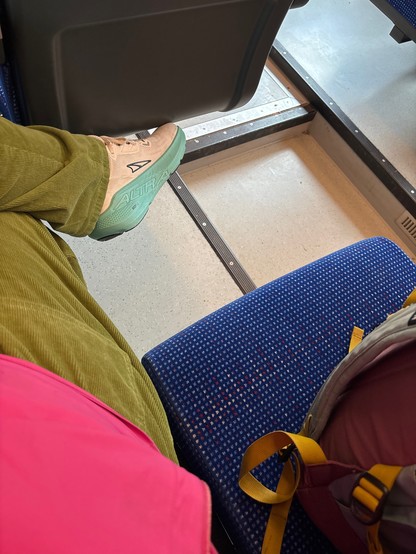Der Fußboden eines Zuges, ein Stück vom Sitz und ein Fuß.