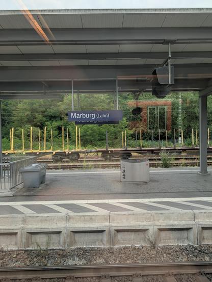 Foto aus dem Zug auf den Bahnsteig mit dem Schild Marburg (Lahn)