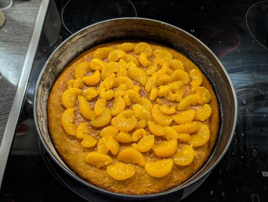 Mandarinenstücke bedecken den Kuchenboden