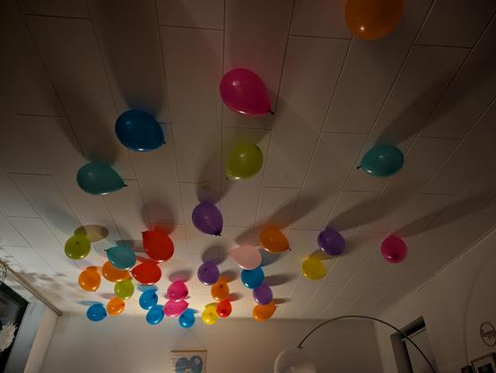 Bunte Luftballons an einer weißen Zimmerdecke 